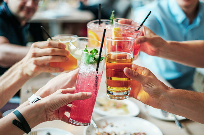 people sitting at a restaurant table clinking glasses